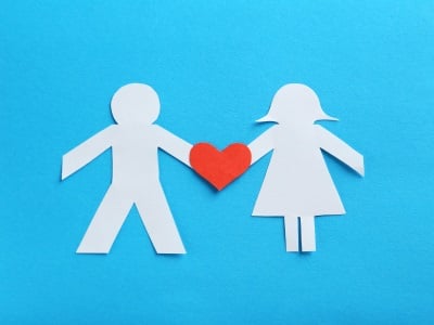 Papierfiguren von einem Mann und einer Frau und Herzen zwischen ihnen