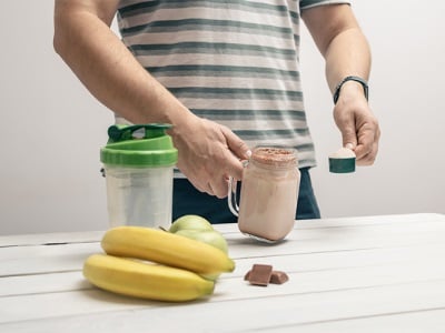 Ein Mann bereitet ein Getr&auml;nk mit Maca-Pulver zu.