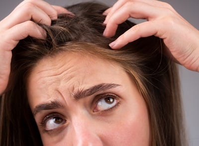 Junge Frau besorgt &uuml;ber Haarausfall